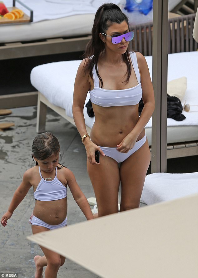 Kourtney Kardashian shows off her perky derriere in tiny bikini bottoms while on holiday